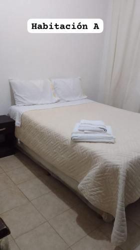 a bed with white sheets and white towels on it at Lo de Dolly in Tartagal
