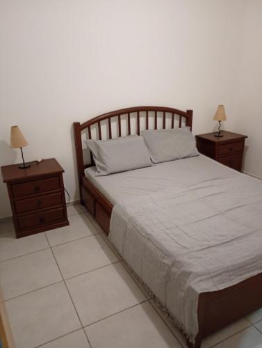 a bedroom with a large bed with two night stands at Apt Térreo in Resende