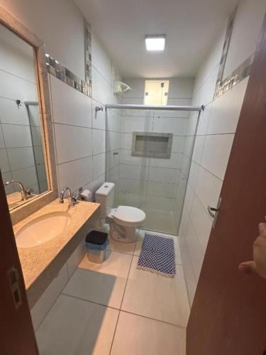 a bathroom with a shower and a toilet and a sink at Residencial Villa dos Corais - Staybeach in Porto Seguro