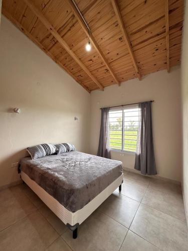 a bedroom with a large bed with a window at Cabaña en cañuelas in Cañuelas