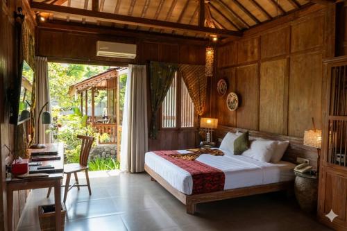 a bedroom with a bed and a desk in a room at Amata Borobudur Resort in Borobudur