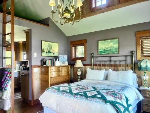 a bedroom with a bed and a chandelier at Beach Kayaks Hot Tub Private Cottage in Friday Harbor