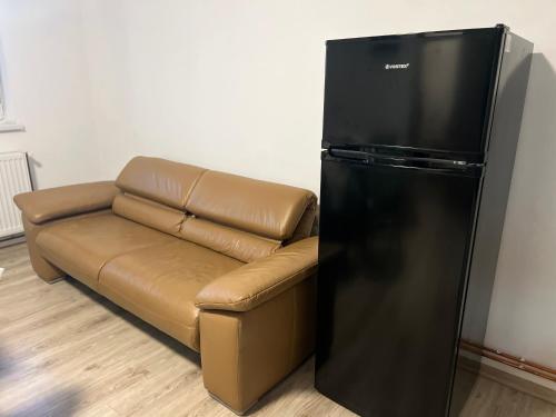 a brown couch next to a black refrigerator at Avram Iancu 365 in Floreşti