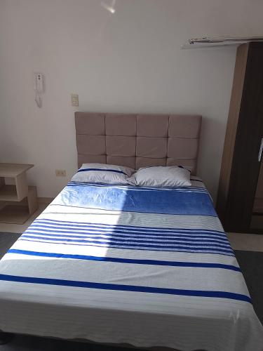 a bed with a blue and white striped mattress at departamento familiar privado trujillo huanchaco in Huanchaco