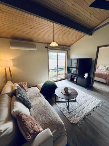 a living room with a couch and a table at Hannahs Haven in Traralgon