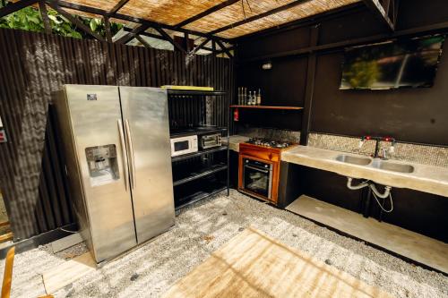 a kitchen with stainless steel appliances and two sinks at Santa Toro Inn, private rooms close to the beach in Santa Teresa Beach