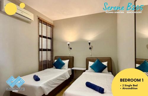 two beds with blue pillows in a room at Harmony Serene 3BR Nomad Sematan Beach Resort in Sematan