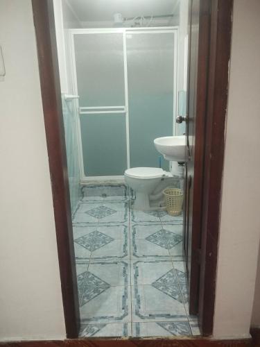 a bathroom with a toilet and a sink at Departamentos La Frontera in Tulcán