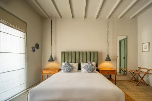 a bedroom with a large white bed and a window at Studio O - Two-Floor Studio, Walk to the Beach in Seminyak