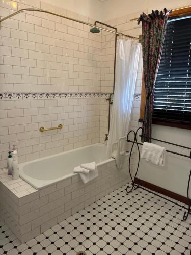 a bathroom with a tub and a tile floor at Bethany Cottages in Bethany