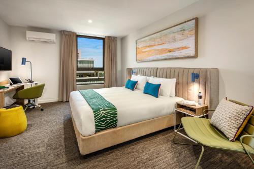 a hotel room with a bed and a desk and a computer at Quest Dandenong Central in Dandenong