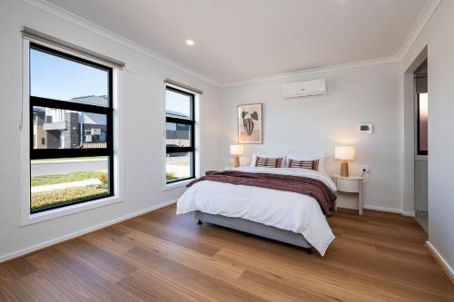 a bedroom with a bed and two windows at Greenview Place - Officer in Officer