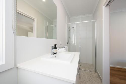a white bathroom with a sink and a shower at Greenview Place - Officer in Officer