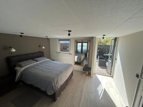 a bedroom with a bed and a view of a patio at 208 Chalet Bosrust in Anloo