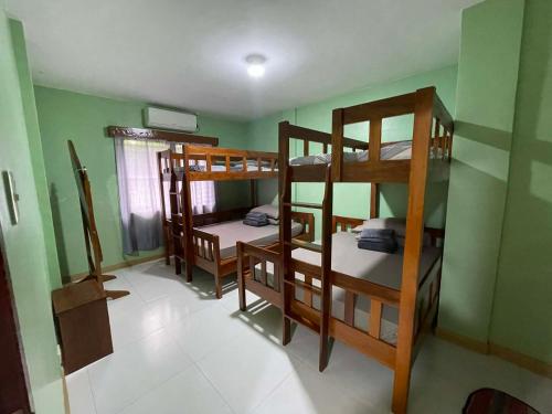 a room with three bunk beds in a room at Kirah's Pension House - 3 to 5 mins from PPIA via commute in Puerto Princesa City