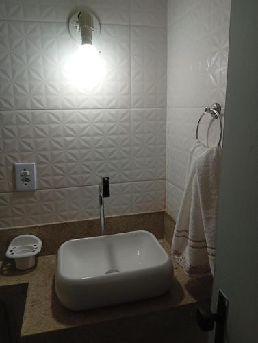 a bathroom with a sink with a light on it at Studio Premium Trianon Centro in Campos dos Goytacazes