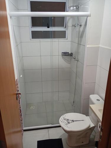a bathroom with a shower with a toilet and a sink at Apt Térreo in Resende
