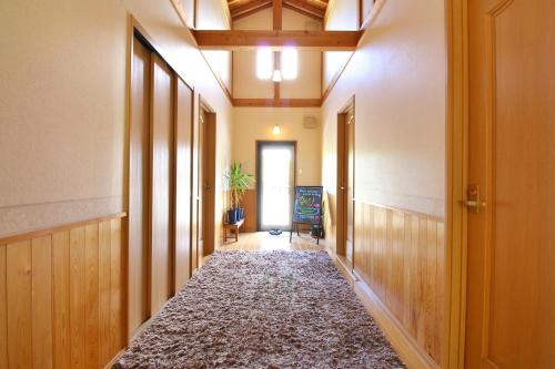 a hallway with a rug in the middle of a room at 民宿なずな in Tosa