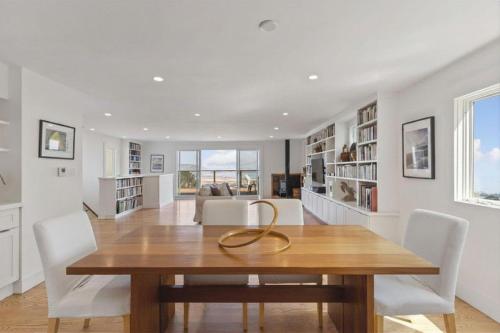 a dining room with a wooden table and white chairs at Stunning Views by the Bay 2BR in Brisbane