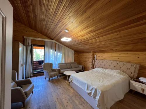 a bedroom with a bed and chairs in a room at Семейный коттедж in Bulan Sogottuu