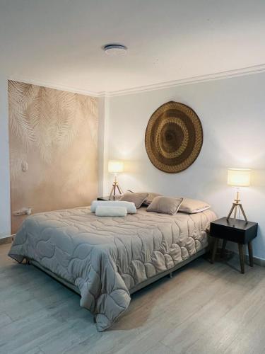 a bedroom with a large bed with two lamps at Casa Ligia in Medellín
