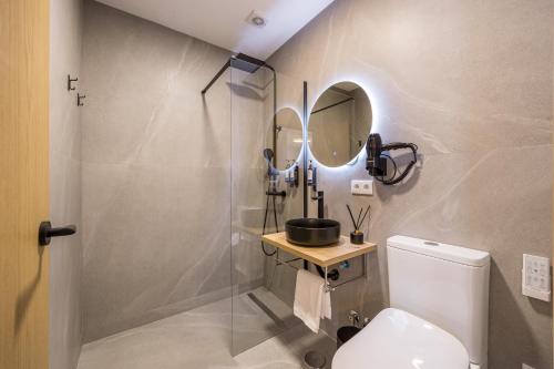 a bathroom with a shower and a toilet and a mirror at La Posada Boutique rooms Albir in Albir