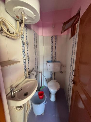 a small bathroom with a sink and a toilet at Omji Ashram - Tapovan Kuti in Uttarkāshi
