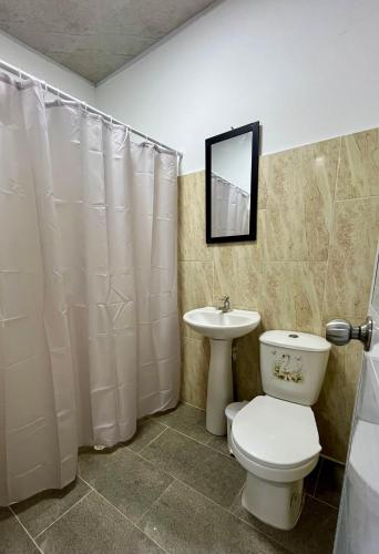 a bathroom with a toilet and a sink at Hotel Roy in Santa Marta