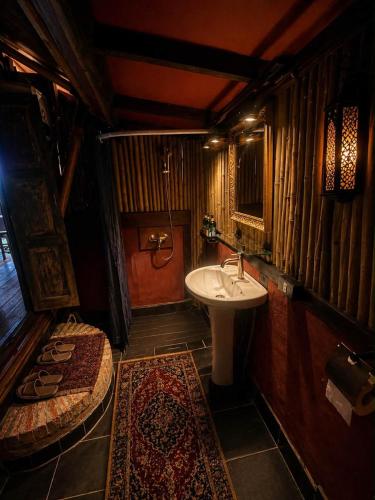 a small bathroom with a sink and a toilet at Chateau Orientale Resort in Luang Prabang