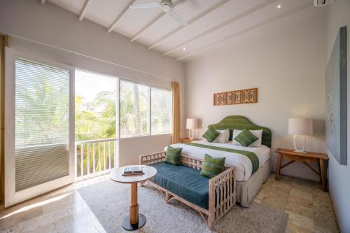 a bedroom with a bed and a chair and a window at Room & Vespa 4 - Central Seminyak Near Beach in Seminyak