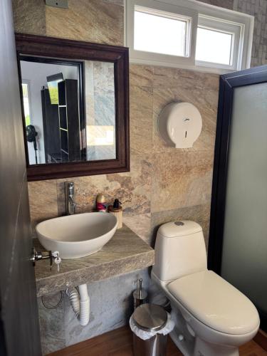 a bathroom with a sink and a toilet and a mirror at Casa Escondida in San Felipe