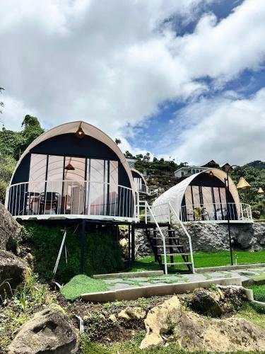 a large building with a tent in a field at Glamping Dieng Sunrise Point Larva Camp in Kejajar