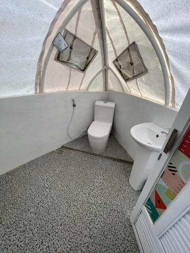 a bathroom with a toilet and a sink in a tent at Glamping Dieng Sunrise Point Larva Camp in Kejajar
