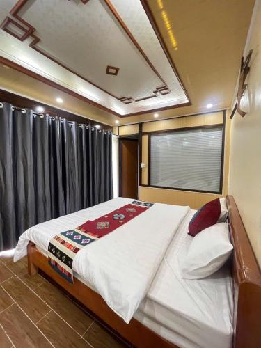 a large bed in a room with a window at MAI CHAU inn in Mai Châu