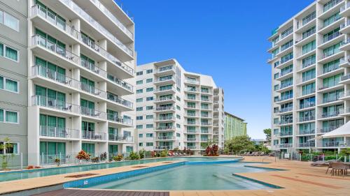 an apartment complex with a swimming pool in front of two tall buildings at Mantra Hotel Room in Cairns