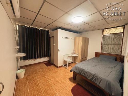 a room with a bed and a table in it at Casa Scarlet in Bangkok