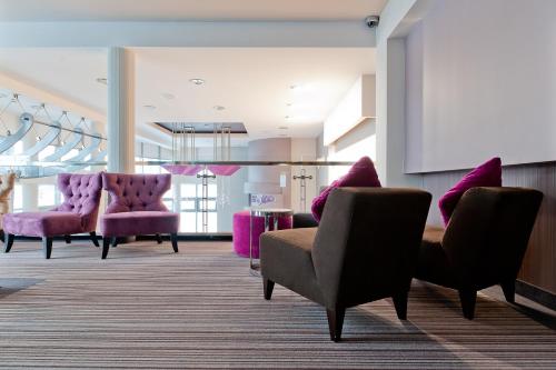 a waiting room with purple chairs and a table at Hotel 3 Trio in Białystok
