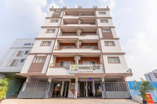 ein hohes weißes Gebäude mit einem Schild darauf in der Unterkunft Treebo Lime Light in Pune