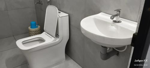a bathroom with a toilet and a sink at Dreamers Lounge in Trichūr