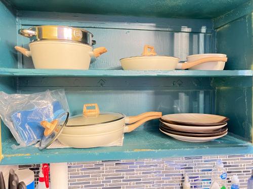 a shelf filled with pots and pans and plates at Pet friendly Newly renovated Two bedroom Property in Central Okc in Oklahoma City