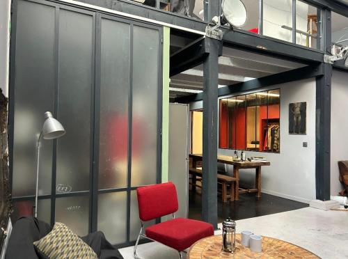 a living room with a red chair and a table at Funky artists studio in Paris in Pantin