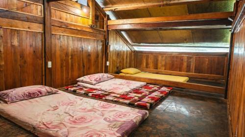 a room with two beds in a wooden cabin at PhinFamilyHomestay in Tả Van
