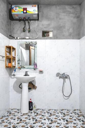 a bathroom with a sink and a shower with a television at PhinFamilyHomestay in Tả Van