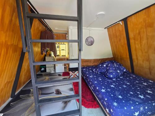 a bunk bed and a ladder in a room with a bed at CK Family in Nakhon Nayok