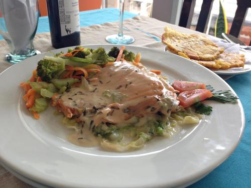 a plate of food with meat and vegetables on a table at Sky Club Eco Hotel in Belén de Umbría