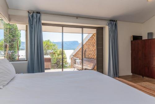 a bedroom with a bed and a large window at 3BR Lakeside Home Mountains Beach Nearby in Cape Town
