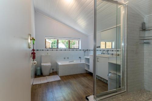 a bathroom with a shower and a toilet and a sink at 3BR Lakeside Home Mountains Beach Nearby in Cape Town