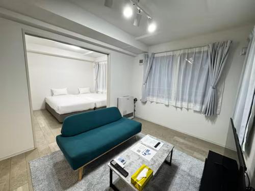 ein Wohnzimmer mit einer grünen Couch und einem Bett in der Unterkunft ハミルトンイースト in Sapporo