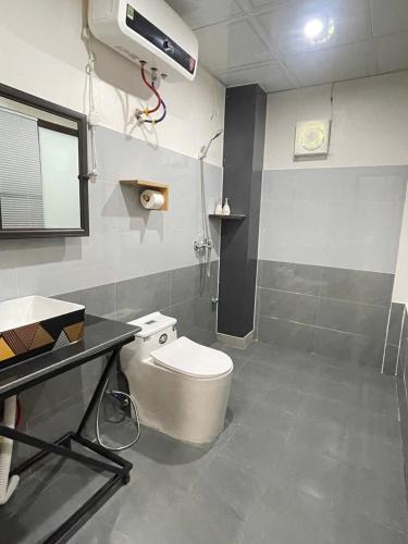 a bathroom with a toilet and a desk and a air conditioner at MAI CHAU inn in Mai Châu