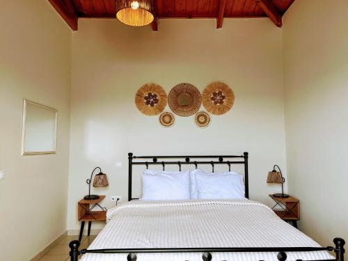 a bedroom with a bed with two mirrors on the wall at ARETOUSA in Agia Pelagia